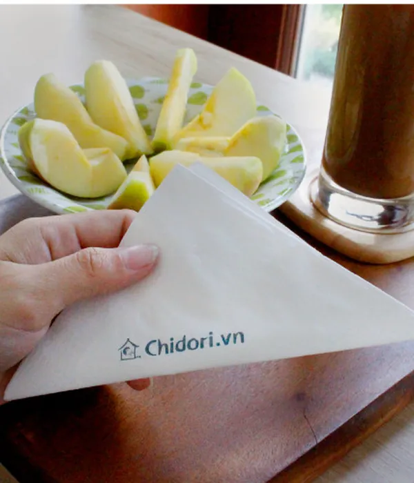 Khăn giấy cocktail đặt cạnh ly cà phê và đĩa trái cây
