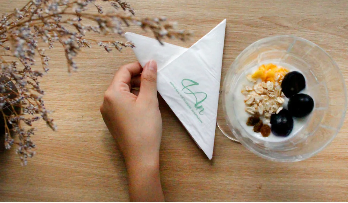 Khăn giấy ăn in logo đặt trên bàn gỗ – Đà Lạt Paper